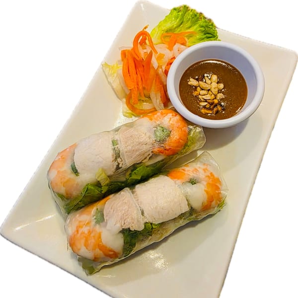 Two fresh Vietnamese spring rolls with shrimp, pork, and vegetables, served with peanut sauce and pickled carrots.